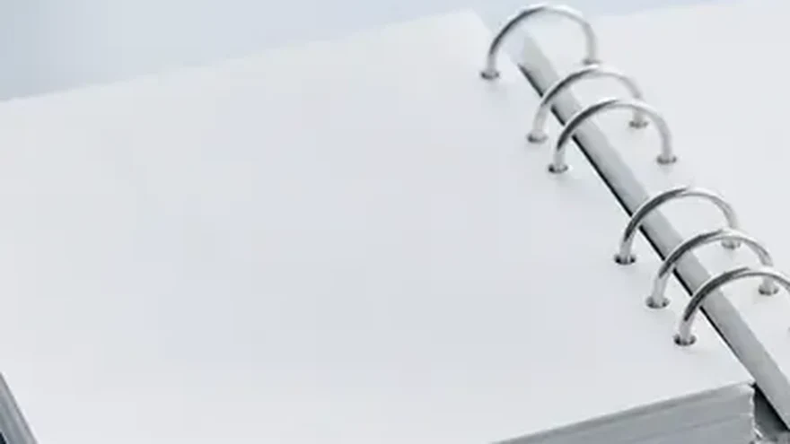 Close-up of the empty rings of an open binder on a white surface